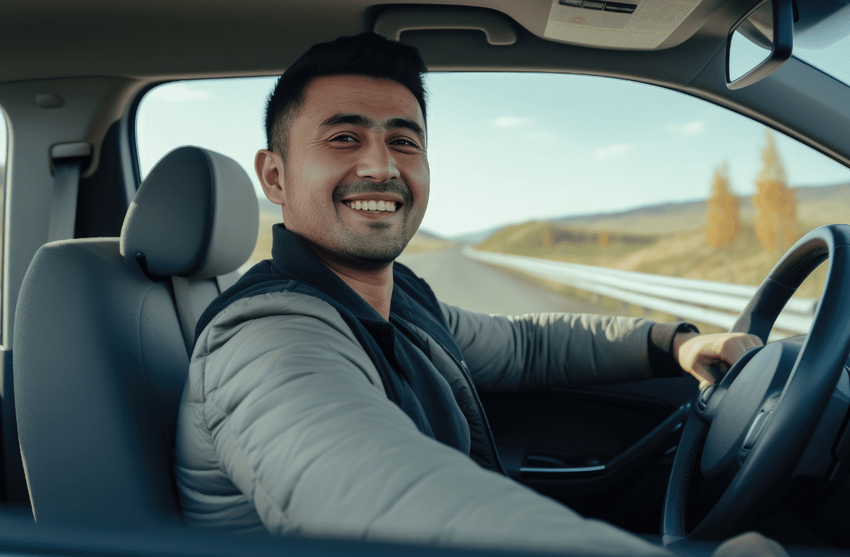 Smiling man in driver's seat of vehicle, ready to drive