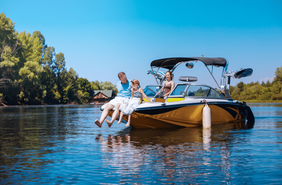 Dad and daughter sit at the bow of a boat while mom drives.