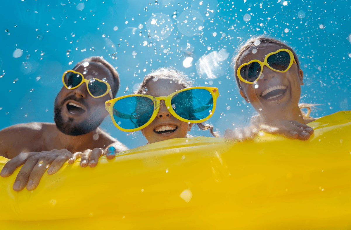 Mom, dad and daughter on yellow innertube with yellow sunglasses