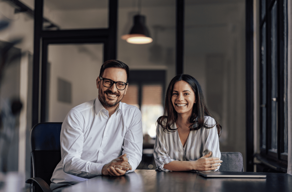 Man and woman business partners sitting at meeting table.