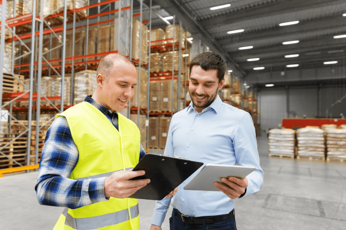 Warehouse manager and business manager discussing insurance documents