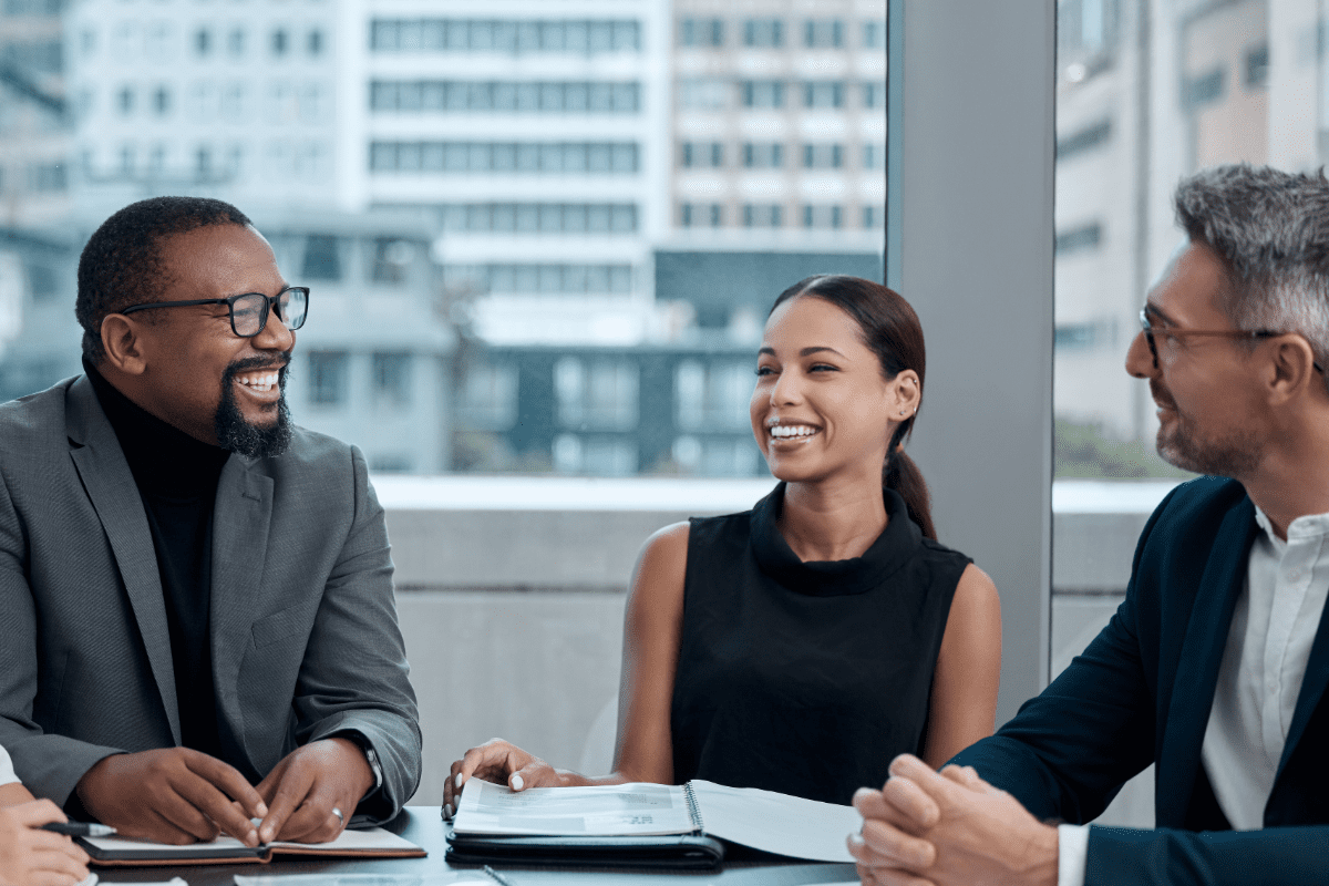 Three people sitting at a table during a business meeting.