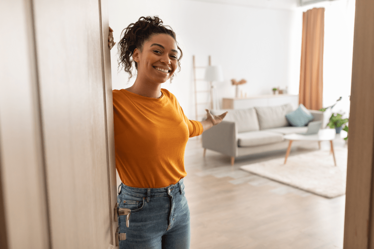 Young woman opening door to her newly rented apartment