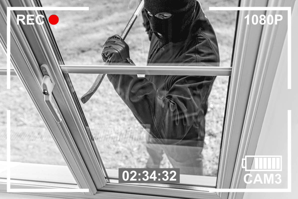 Security camera photo of a masked person breaking into a home.